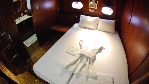 A comfortable cabin on the Gulet Sahinoğlu, with a cosy double bed.